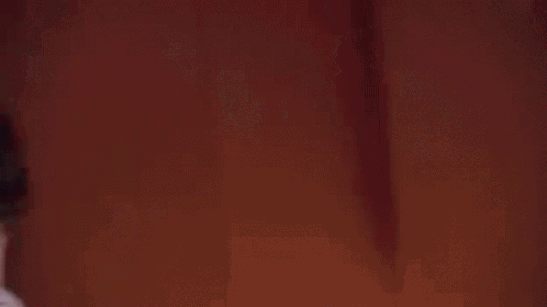 a close up of a man 's face in a dark room with a shadow on his face .