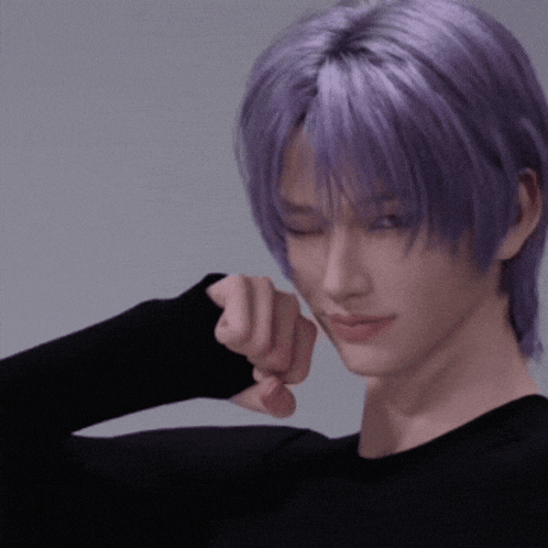 a man with purple hair is wearing a black top