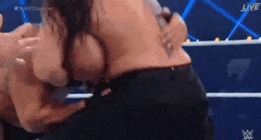 a man and a woman are wrestling in a wrestling ring without shirts on .