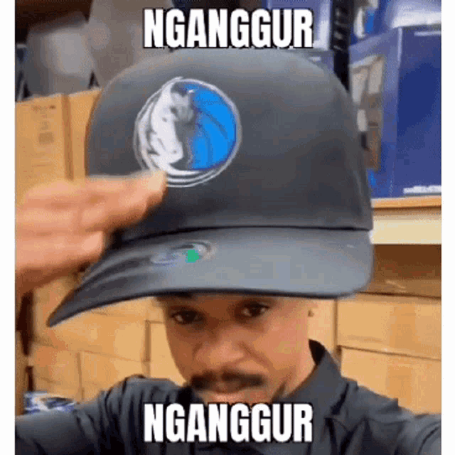 a man wearing a baseball cap with the word nganggur on it