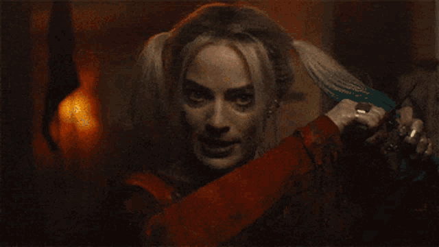harley quinn holding a pair of scissors in her hand