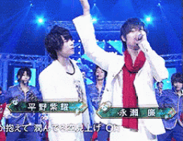 a couple of men standing on a stage with chinese writing