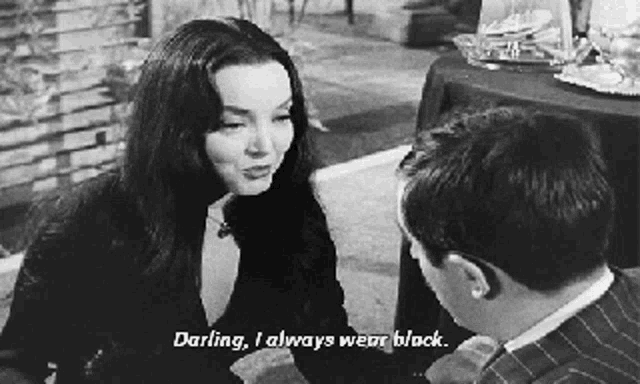 a woman is talking to a man in a black and white photo and says `` darling , i always wear black '' .