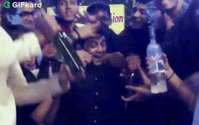 a group of people are gathered around a man holding a bottle of vodka in front of a sign that says union