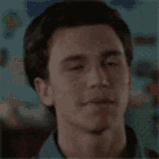 a close up of a young man 's face smiling in a blurry photo .