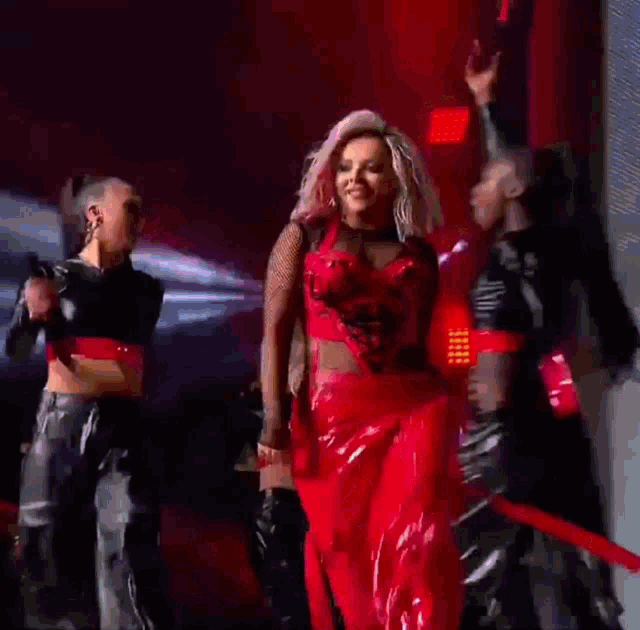 a woman in a red dress is standing on a stage