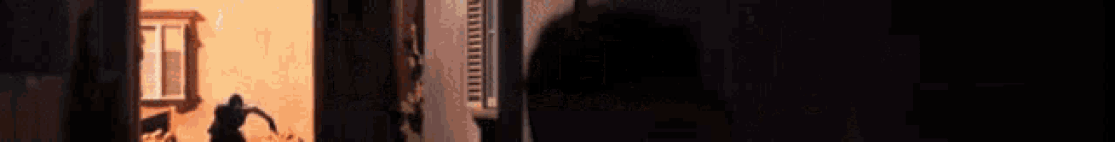 a blurred image of a person standing in front of a wall with the letters ii and iii visible
