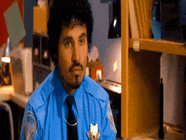 a man wearing a blue shirt and tie has a badge that says ' n.y.p.d. ' on it