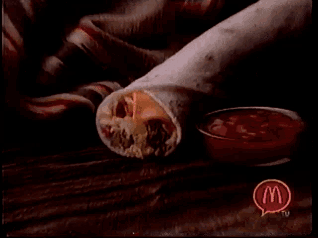 a mcdonald 's advertisement shows a burrito and ketchup on a table