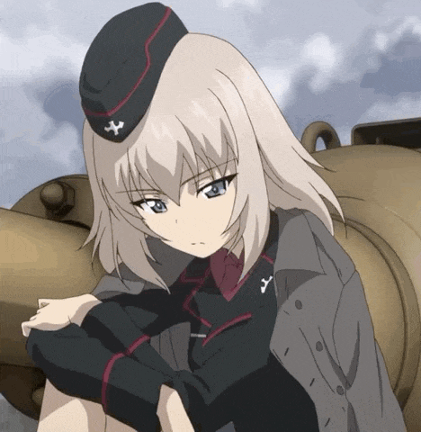 a girl wearing a hat with a cross on it sits in front of a tank