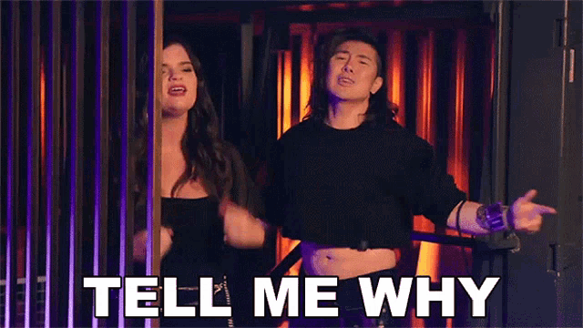 a man and a woman are standing next to each other and the man is pointing at the woman .