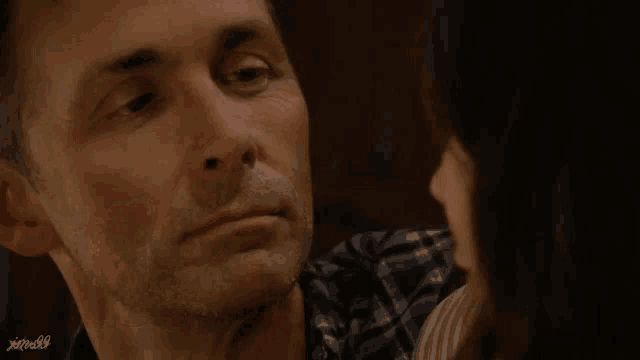 a man and a woman are looking at each other and the man 's face is visible in a blurry photo