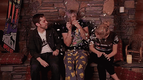 three people sitting on a couch with one wearing a shirt that says future on it