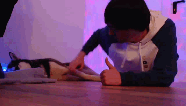 a man giving a thumbs up while laying on the floor
