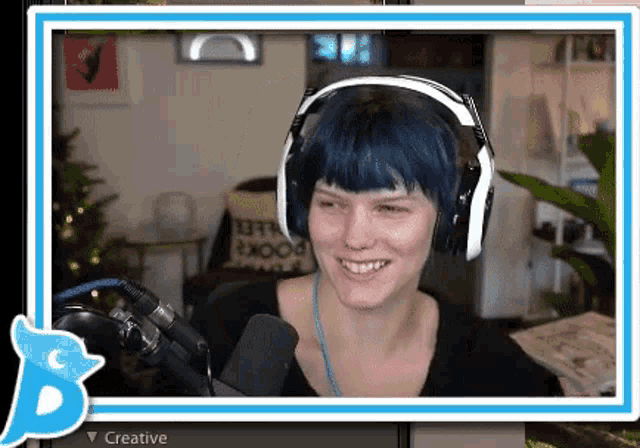 a woman wearing headphones is smiling in front of a microphone and the word creative is on the bottom
