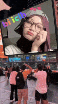 a woman wearing glasses and a hat is on a screen that says bi ichi