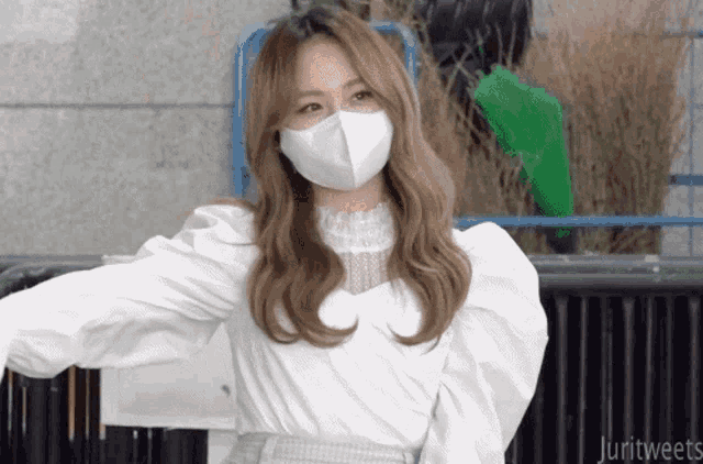 a woman wearing a white face mask with the words jurittweets written below her