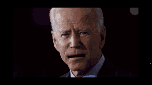 a close up of biden 's face with a purple background