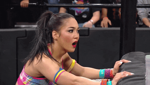 a woman with a surprised look on her face is wrestling