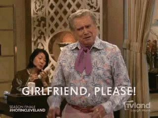 a man with a pink tie is standing in a room and says girlfriend please .