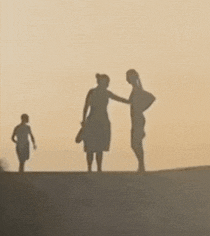 a group of people are standing on top of a hill .