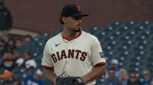 a baseball player wearing a giants jersey throws a ball