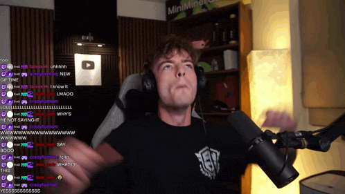 a man wearing headphones stands in front of a microphone in front of a sign that says minimineral