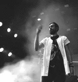 a man with a beard is standing on a stage in a black and white photo .