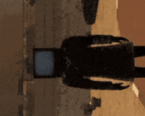 a shadow of a person standing next to a television screen