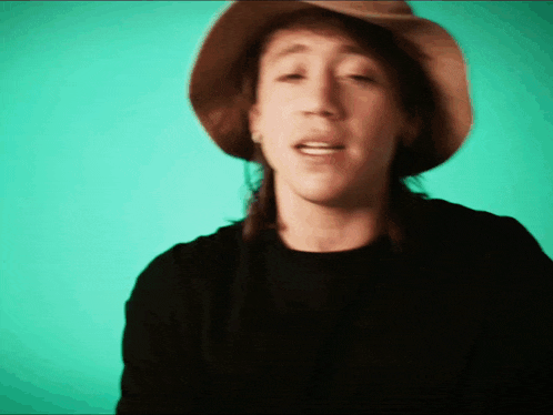 a man wearing a hat and a black shirt is singing