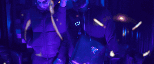 two men are standing next to each other in purple jackets and hoodies .