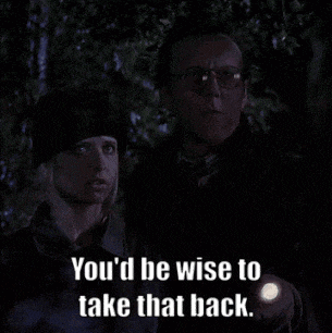a man holding a flashlight next to a woman says you 'd be wise to take that back