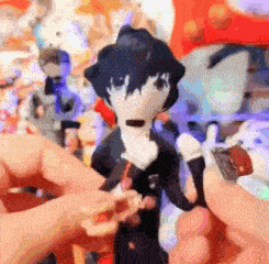 a person is holding a stuffed animal in their hand in front of a bunch of stuffed animals .