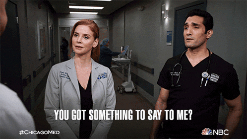 a man and a woman are standing in a hospital hallway and the man asks the woman if she has something to say to him