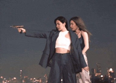 a woman pointing a gun at another woman