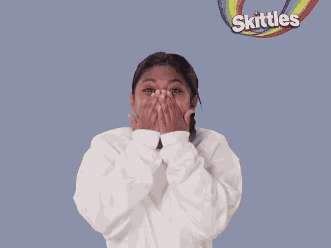 a woman is surrounded by skittles candy and laughing