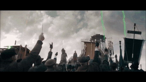 a crowd of people are holding up their arms in the air
