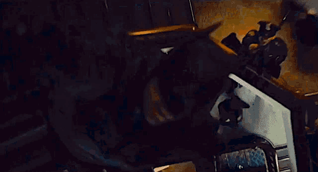 a person is laying on a bed in a dark room and looking down .