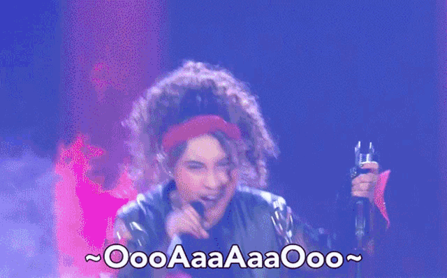 a woman singing into a microphone with the words oooaaaaaooo written on the bottom