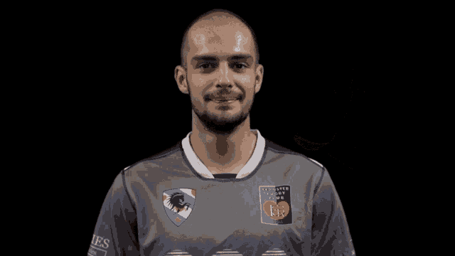 a man wearing a gray shirt with the word es on the sleeves