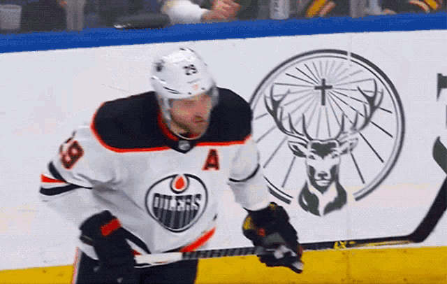 a hockey player wearing a white jersey with the letter a on it