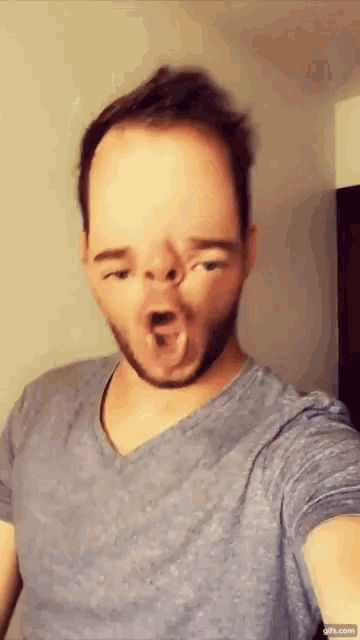a man with a beard is making a funny face with his mouth wide open