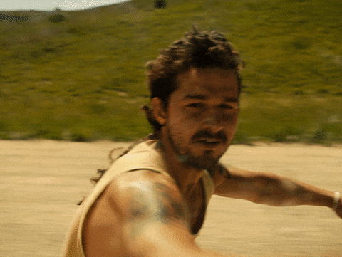 a man with a beard and a tattoo on his arm is wearing a tank top