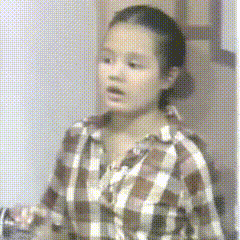 a girl wearing a plaid shirt is looking at something