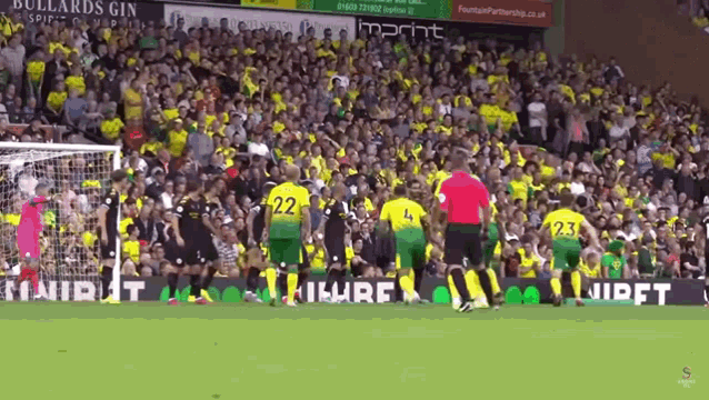 a soccer game is being played in front of a large crowd and a sign that says imprint