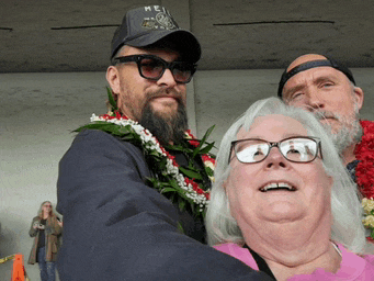 a man with a beard wearing a hei hat stands next to a woman with glasses