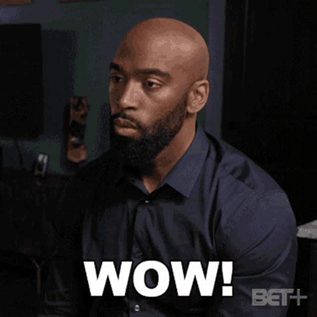 a man in a blue shirt says wow on the screen