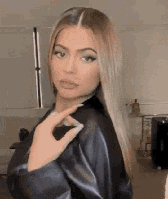 a woman in a black leather jacket is making a face