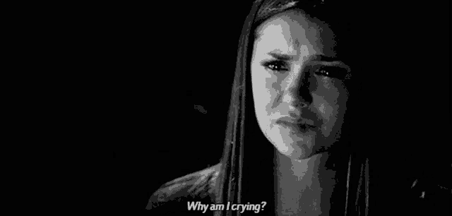 a black and white photo of a woman crying with a tear coming out of her eye .