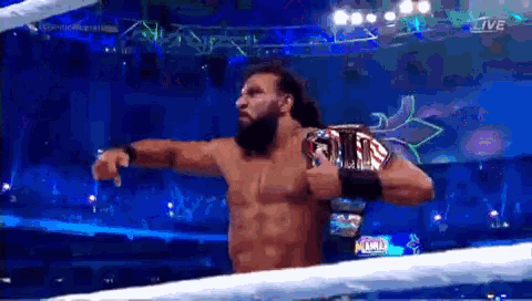 a man with a beard is holding a wrestling championship belt